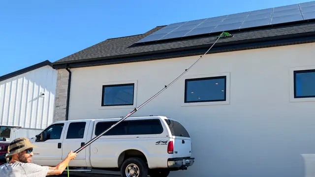 Limpieza de paneles solares en el techo con un poste de agua pura